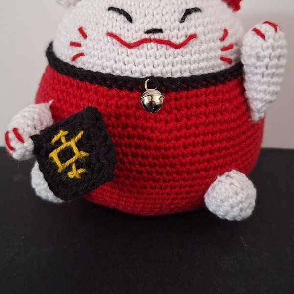 Chat porte-bonheur rouge et blanc avec un grelot doré