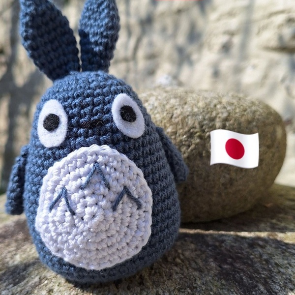 Amigurumi bleu aux longues oreilles, devant un petit drapeau japonais